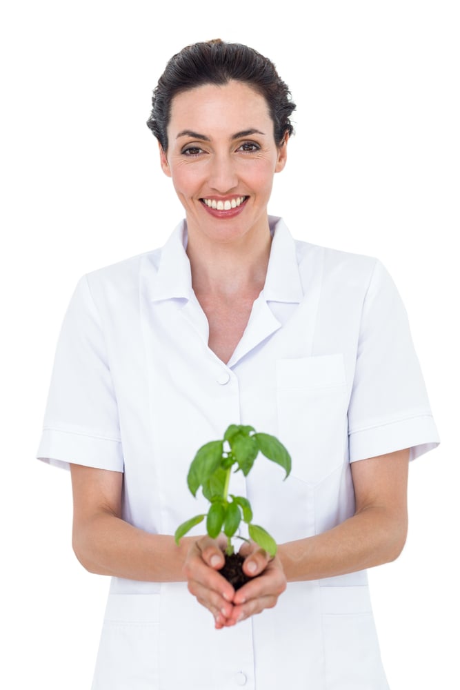Scientist holding basil plant on white background