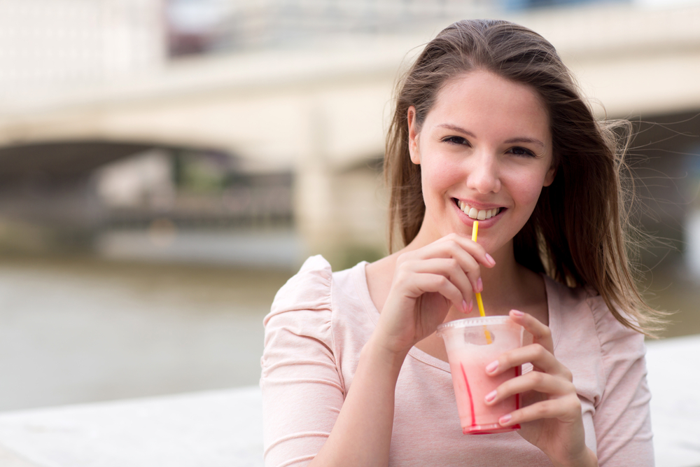 Beautiful woman having a smoothie on a summery day
