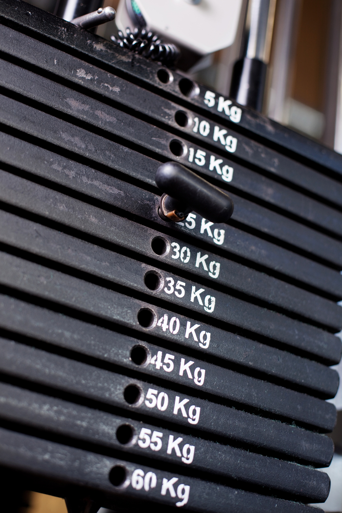 Close up of weights in a gym with the pin at 25kg