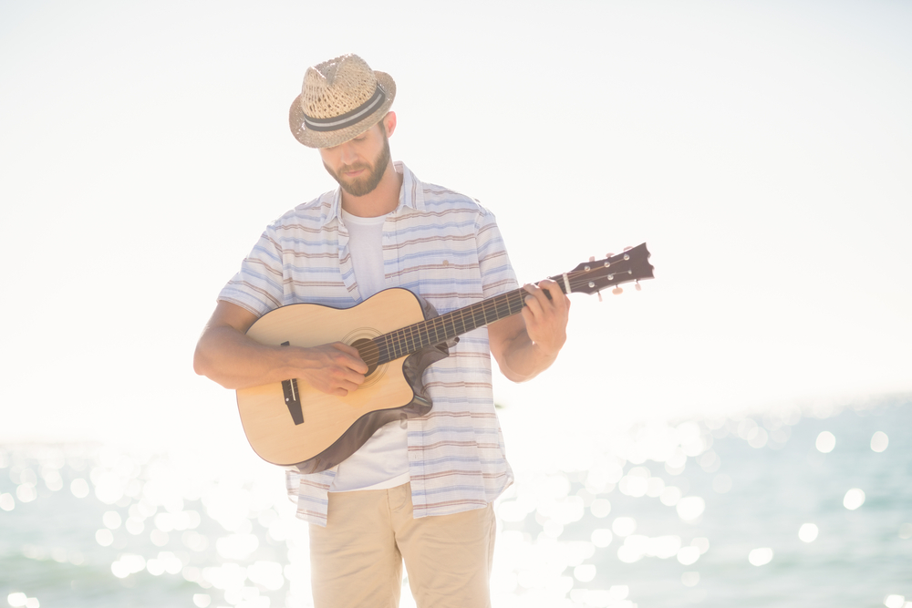 Musician playing guitar on the beach